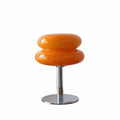 Lampe de table Dimoree style macaron en verre soufflé orange brillant avec pied en métal chromé sur fond blanc